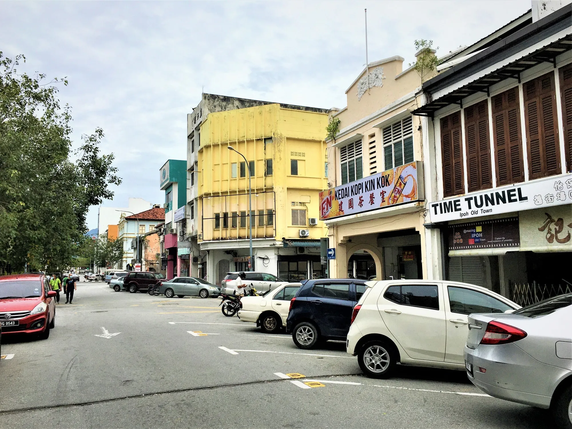 怡保旧街场的 Jalan Panglima，色彩缤纷的两层店屋前停着汽车，天空多云