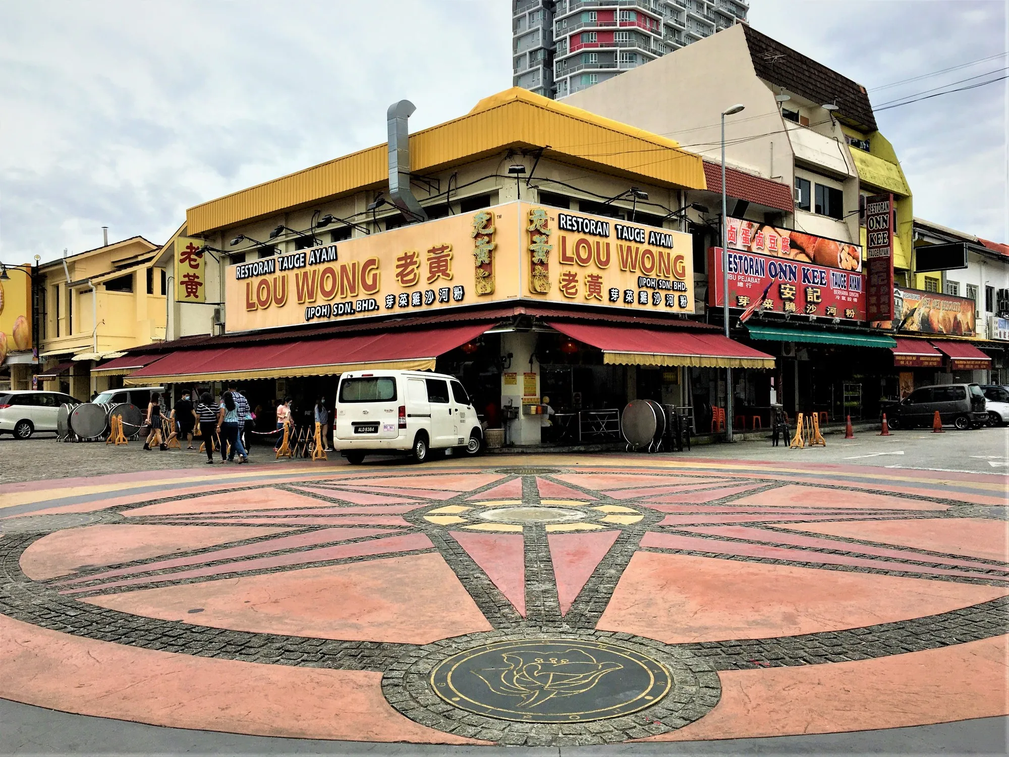 Restoran di rumah kedai simpang dengan papan tanda kuning dan dataran berturap bercorak di Jalan Yau Tet Shin, Ipoh